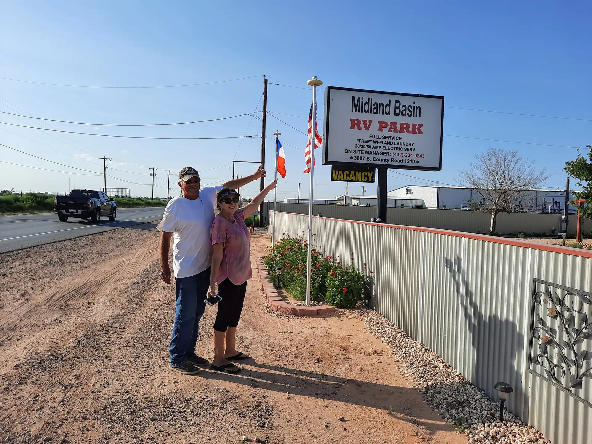 a couple pointing to the rv park sign