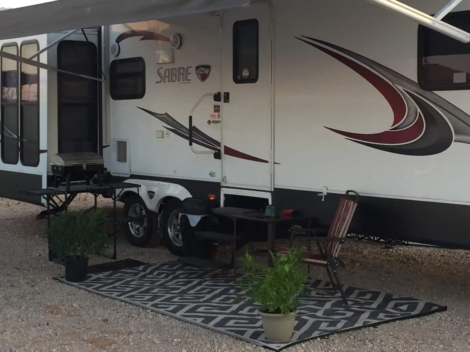 an rv with a carpet and chair outside